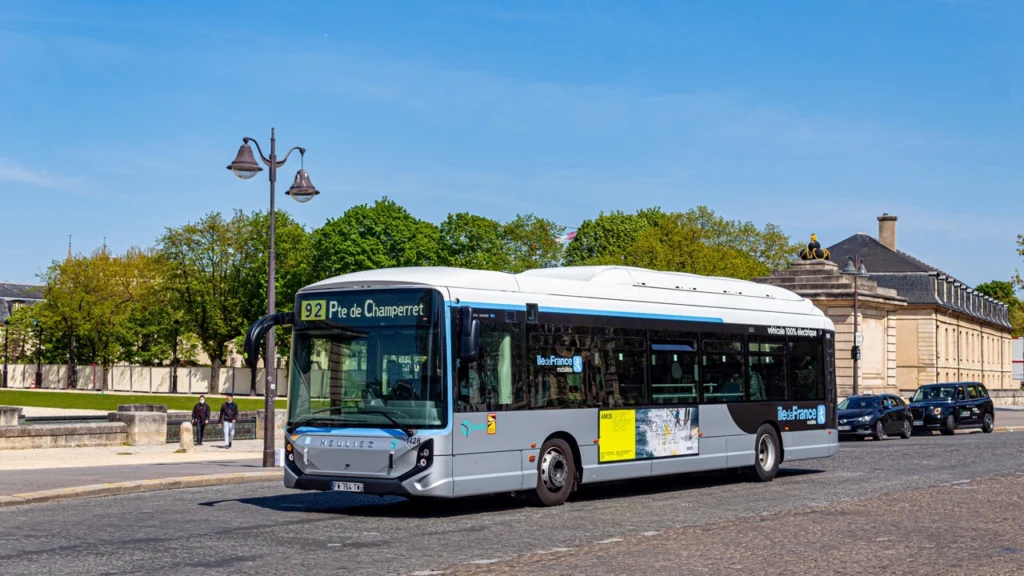 bus électrique bleu et blanc de la RATP circulant en zone urbaine parisienne