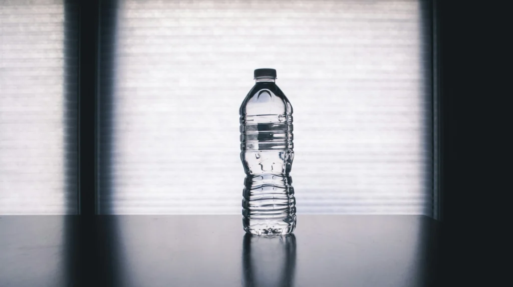 bouteille d'eau pure et transparente sur surface réfléchissante avec lumière naturelle