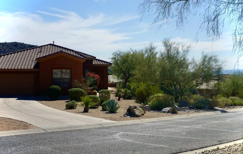 House with desert landscaping and driveway under a clear sky.