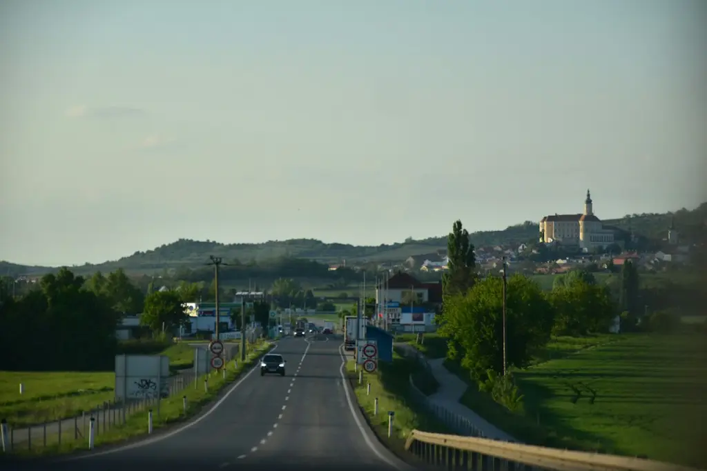 Road leading to a village with a church on hill