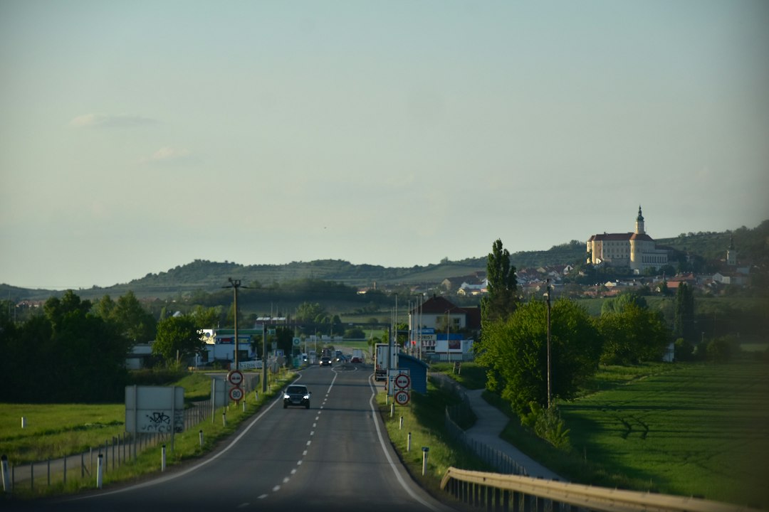 Road leading to a village with a church on hill